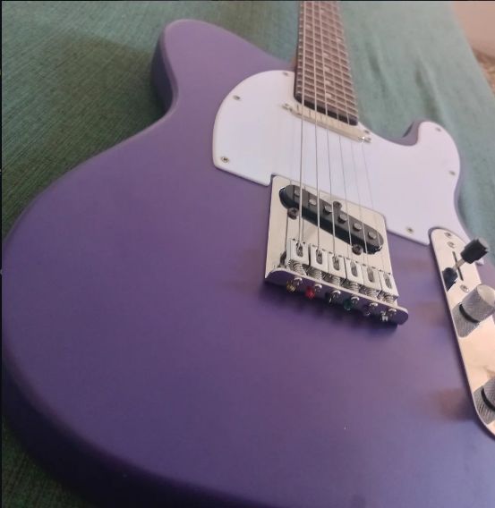 Guitarra eléctrica artesanal morada, detalle del puente y las pastillas